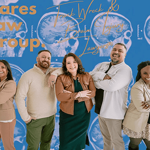 Nares Law Group legal team standing confidently in front of a blue background with brain scan graphics and gold text that reads “Truck Wreck & Brain Injury Lawyers.”