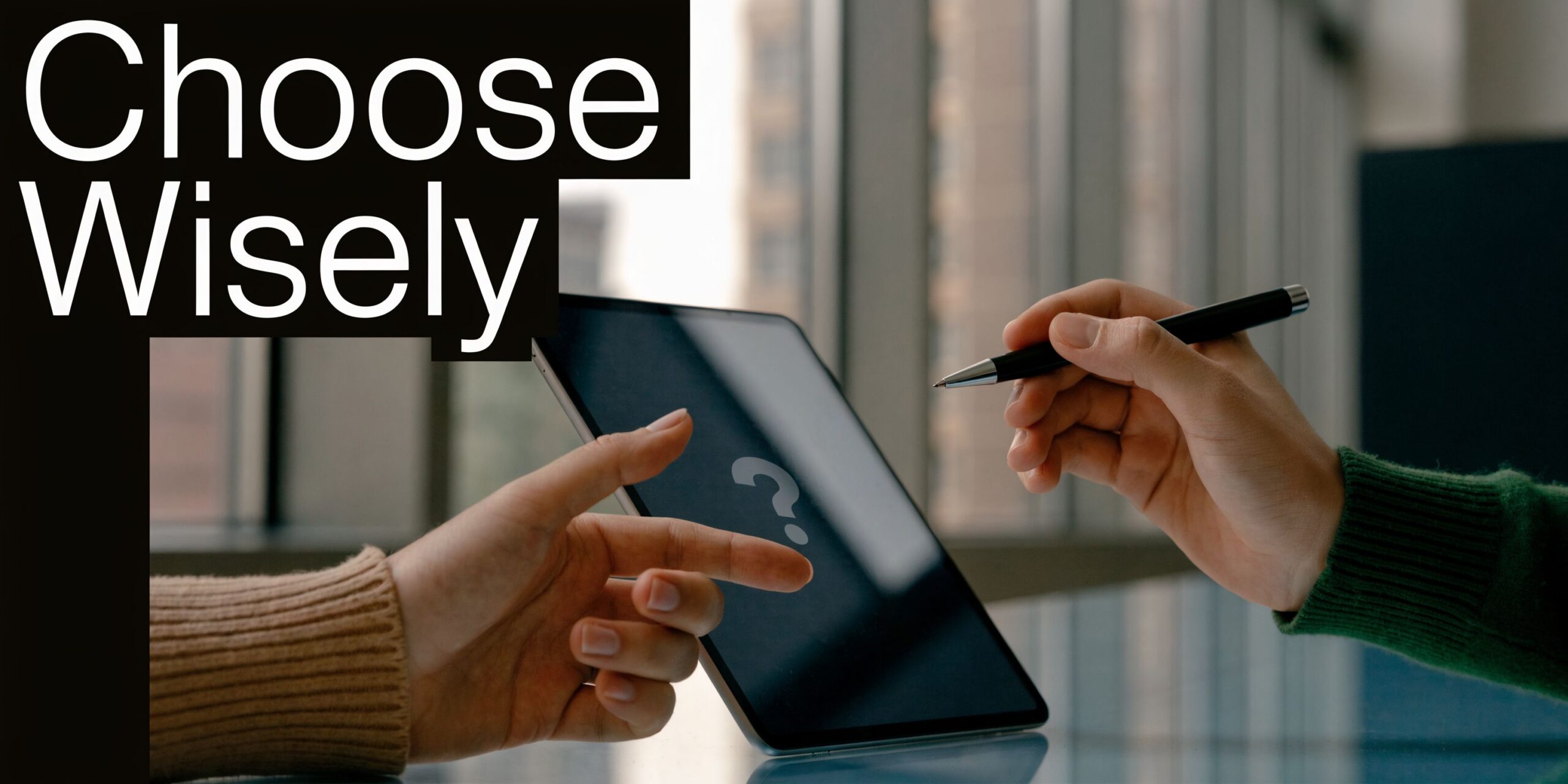 A person uses a digital tablet while another person points at a question mark icon on screen.